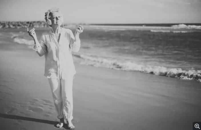 lady walking on the beach listening to music